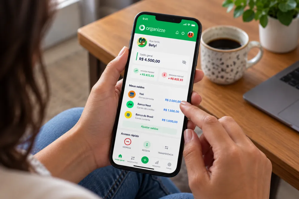 App de gastos mensais aberto no celular mostra saldo, receitas, despesas e contas bancárias.