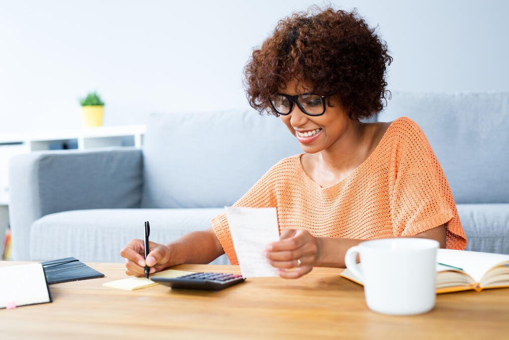Inteligência financeira: o que é, benefícios e como desenvolver a habilidade 3 mulher calculando despesas depois de aprender sobre inteligência financeira
