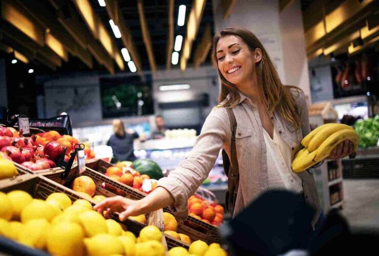 Mulher fazendo compras depois de aprender como economizar no supermercado.