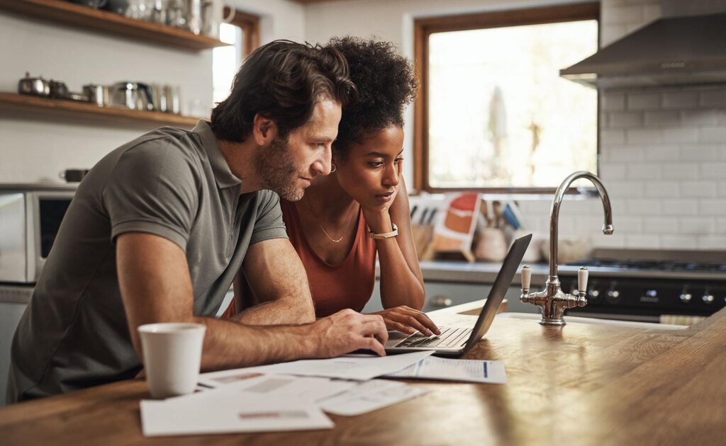 casal usando o computador para aprender como fazer conciliação bancária