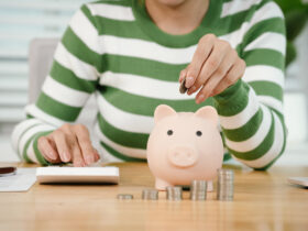 Pessoa calculando finanças pessoais e guardando dinheiro no cofrinho depois de entender como funciona aposentadoria privada na prática.