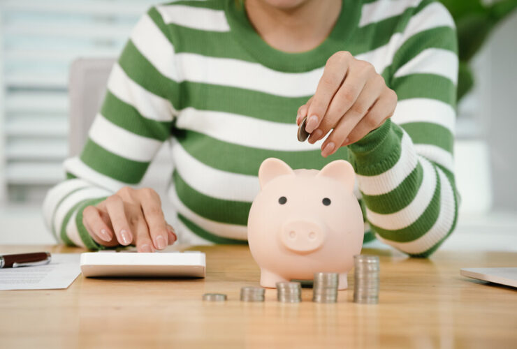Pessoa calculando finanças pessoais e guardando dinheiro no cofrinho depois de entender como funciona aposentadoria privada na prática.