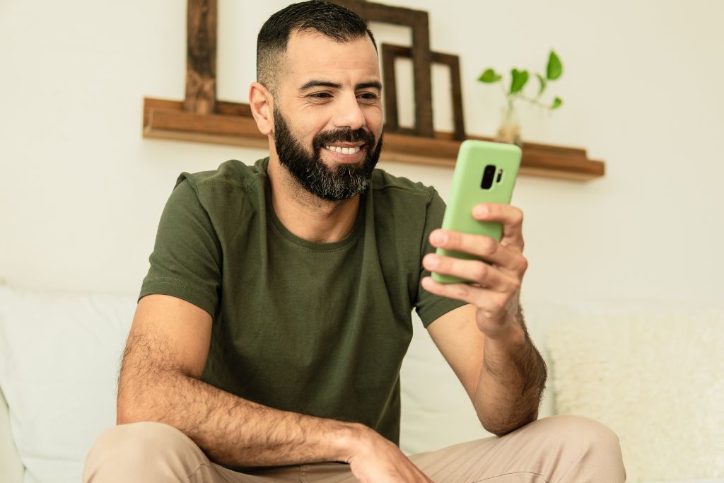 Homem pesquisando no celular como funciona aposentadoria privada e acompanhando aportes de investimentos para planejar o futuro com a ajuda do app Organizze.