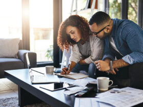 casal anotando finanças e pesquisando no notebook como organizar as contas da casa