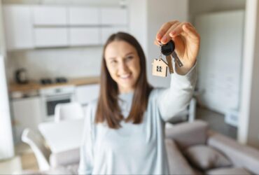 Imagem de mulher com chave na mão, depois de decidir entre comprar ou alugar imóvel - Oganizze Blog