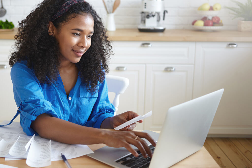 mulher usando o computador para saber como pagar dívida caducada