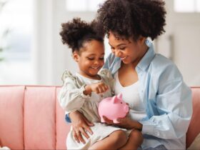 mãe usando cofrinho para ensinar educação financeira infantil para filha