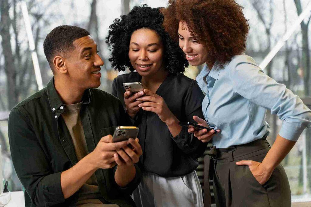 Profissionais discutem ideias sobre o futuro das finanças usando celulares.