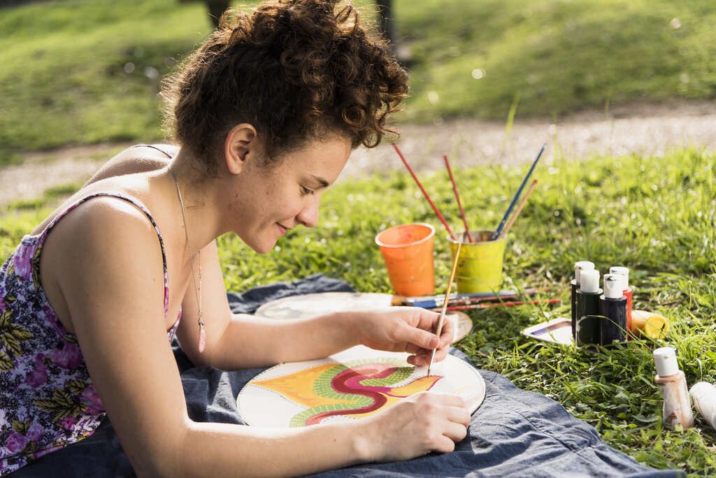 mulher praticando pintura depois de reduzir gastos com hobbies