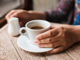 Pessoa com xícara de café, representando os gastos diários com alimentação.