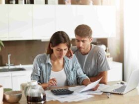 Casal jovem fazendo as contas para saber como limpar nome sujo.