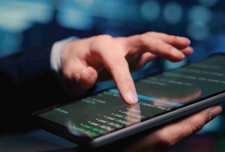 O que são APIs bancárias e como elas funcionam na prática para facilitar o dia a dia 3 Pessoa interagindo com código em tablet, mostrando na prática o que são APIs bancárias