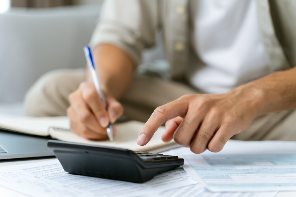 pessoa usando calculadora para saber como fazer um planejamento financeiro