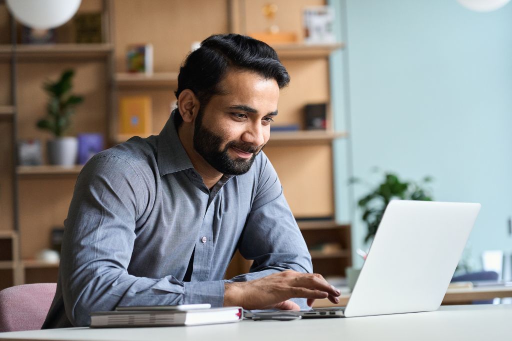 homem pesquisando no notebook sobre investimentos de baixo risco