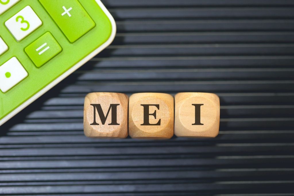 cubos de madeira com as letras formando a sigla MEI, representando o limite de faturamento MEI