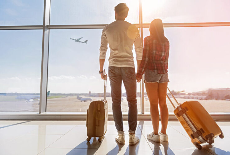 casal com malas em aeroporto, usando o melhor cartão para milhas para viajar