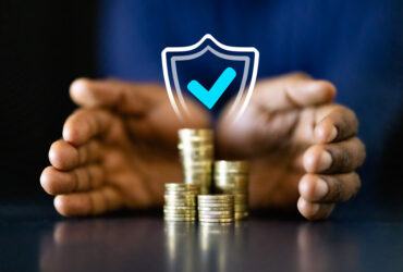 mãos segurando moedas representando onde investir reserva de emergência