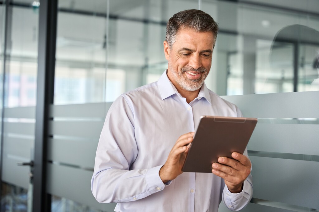 homem usando tablet para ler livros de investimento