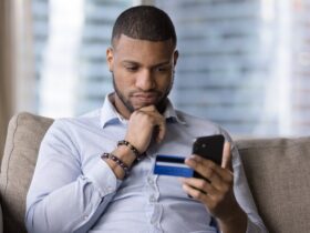 homem mexendo no celular, analisando qual banco digital rende mais