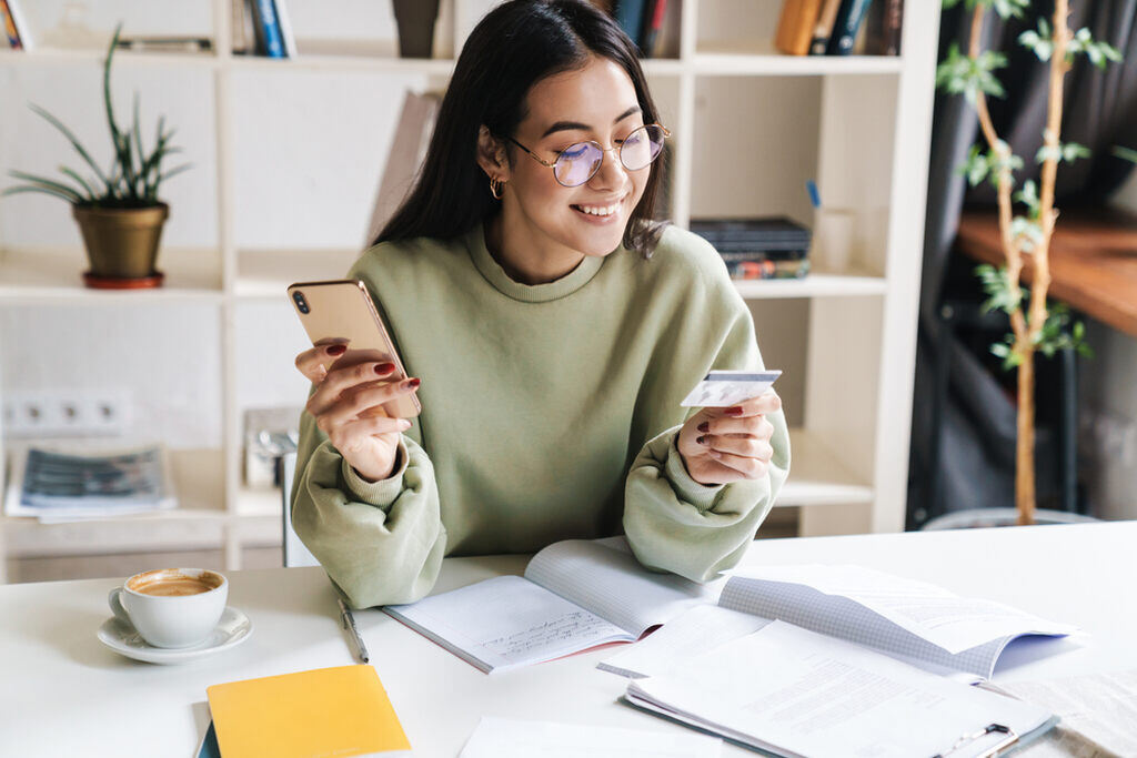 Uso consciente do cartão de crédito: evite dívidas e ganhe controle 2 profissional fazendo compras pelo celular depois de saber como realizar o uso consciente do cartão de crédito