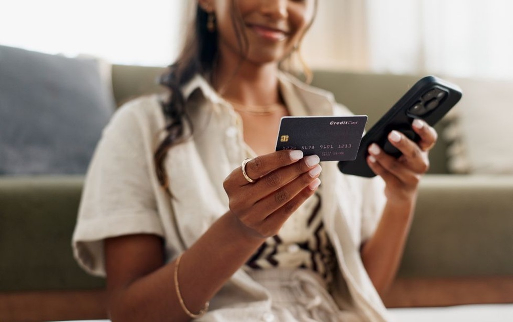 pessoa fazendo uso consciente do cartão de crédito para compras online pelo celular